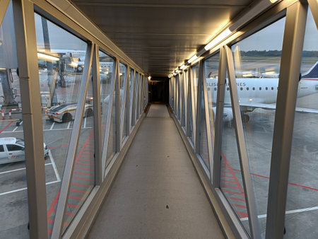 A long corridor in an airport with a lot of planes in the background