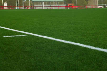 Soccer field with white line on green grass, closeup of photo