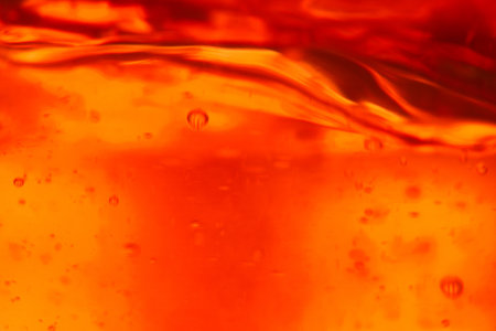 Orange liquid with bubbles close-up. Abstract background for design.の写真素材