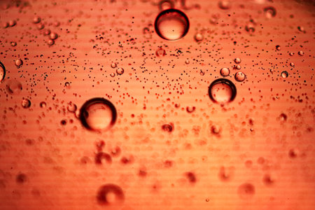 Red water drops on orange background. Macro shot. Abstract background.