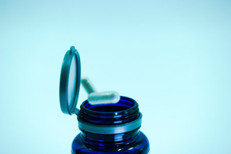 Eye drops in a jar on a blue background. Selective focus.の写真素材