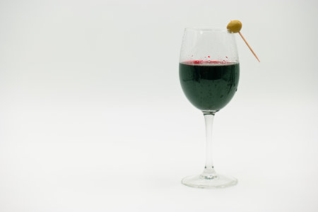 Red wine in a glass with a straw on a white background.の写真素材