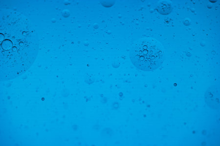 Drops of water on the water, blue background with bubbles.の写真素材
