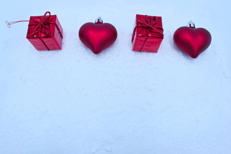 Red heart and gift boxes on white snow. Valentines day backgroundの写真素材