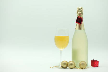Champagne bottle and two glasses with christmas decorations on white backgroundの写真素材