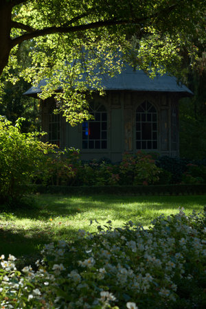 Gazebo in the park with green grass and flowers.の写真素材