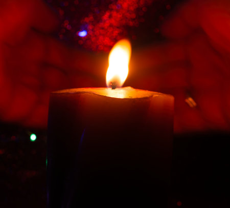 Burning candle on dark shiny background atmospheric sceneの写真素材