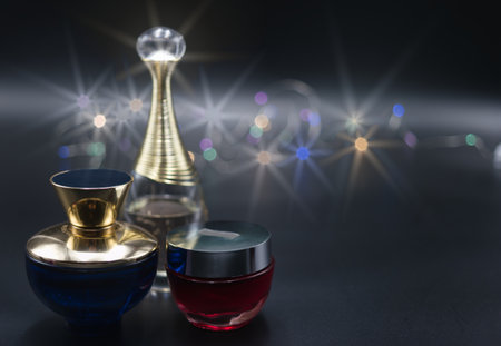 a bottle of perfume on a black background illuminated with colored lightsの写真素材