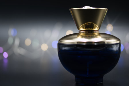 a bottle of perfume on a black background illuminated with colored lightsの写真素材