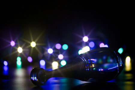a bottle of perfume on a black background illuminated with colored lightsの写真素材