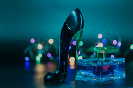 a bottle of perfume on a black background illuminated with colored lightsの写真素材