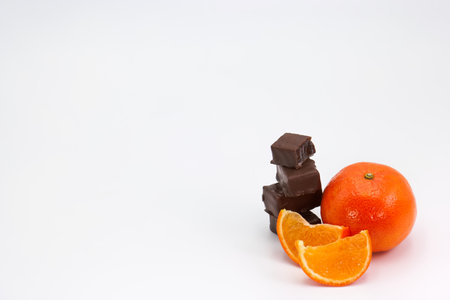 a whole orange with slices of chocolate next to itの写真素材