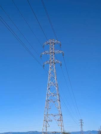 electricity transmission pole against the blue sky