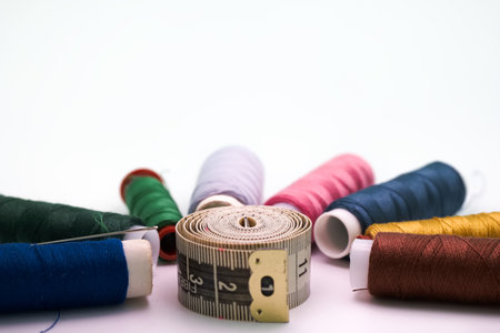 sewing threads and materials cut off on a white background