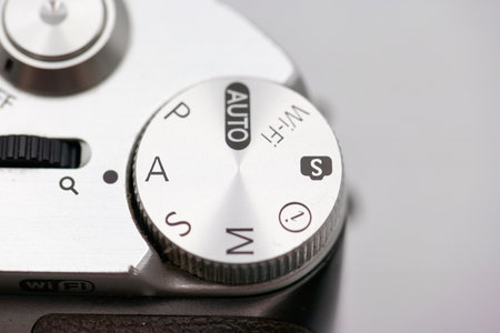 Close up view of a camera settings dial displaying modes such as auto, manual, and wireless. This...
