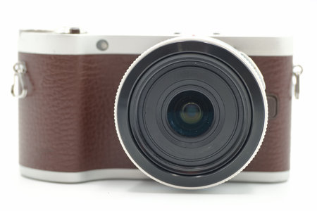 This stylish mirrorless camera showcases a leather like body, featuring a large lens and sleek design. Perfect for capturing memories or artistic shots in various settings.の写真素材