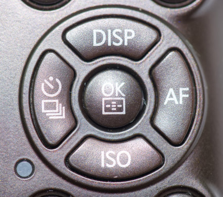 Close up view of a camera control panel showing buttons for display, autofocus, ISO settings, and the OK function, suitable for photographers adjusting settings during shoots.の写真素材