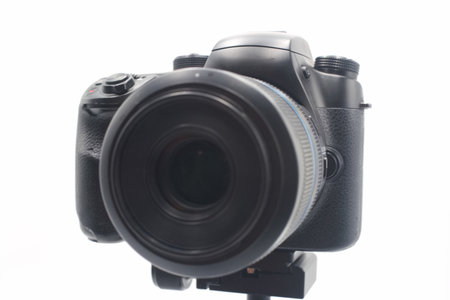 A professional DSLR camera showcases its large lens mounted on a tripod, emphasizing the craftsmanship and design elements. The clean white background highlights the camera's features.の写真素材