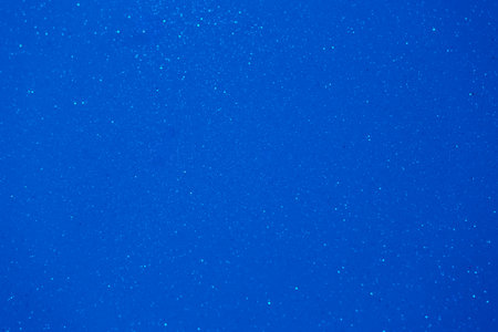 A deep blue backdrop displays shimmering particles scattering light, evoking tranquility and calmness as if capturing a peaceful moment at sunset.の写真素材
