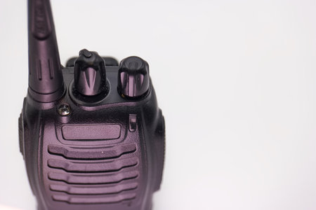 A communication device featuring an antenna and adjustable knobs rests against a plain background. This device is essential for maintaining clear communication in various settings.の写真素材