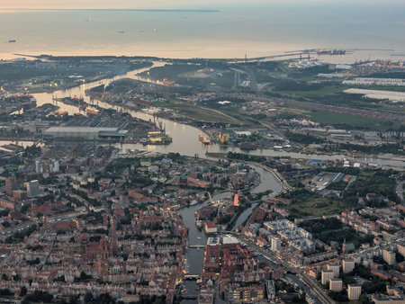 An aerial view captures a vibrant city near a busy harbor at sunset.の写真素材
