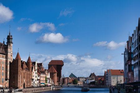 Historic buildings with distinctive architecture line the riverbank in Gdansk. Modern design...