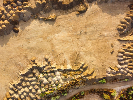Construction activity is evident on the cleared land, where soil and debris are organized in stacks...