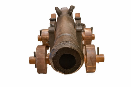 A large cannon rests on wooden wheels, highlighting its historical craftsmanship. The rusted metal...