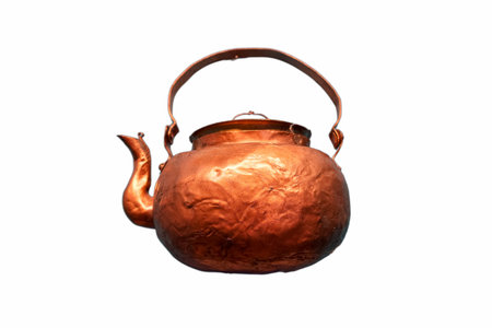 A beautifully crafted copper kettle hangs against a white backdrop. Its rounded body and spout reflect a classic design, exhibiting the skill of metalwork. This piece captures nostalgia and artistry.の写真素材