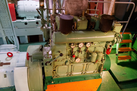 A close up view of a marine engine room featuring intricate machinery. Various gauges and pipes...