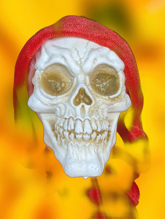 A decorative skeleton head wears a bright red scarf and stands out against a colorful, festive background. Its cheerful expression adds a playful touch to the celebration.の写真素材