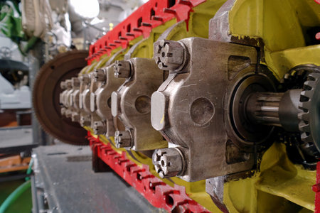 A detailed view of engine parts showcases intricate metal components in a workshop. The bright...