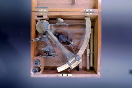 A collection of navigational tools is neatly arranged inside a wooden box. These instruments reflect the craftsmanship of past centuries and are used for navigation at sea and land.の写真素材