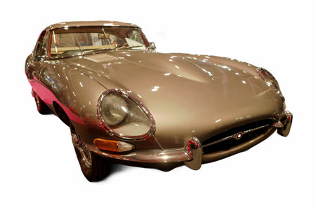 A classic car is displayed at an auto show. The vehicle has a shiny body, clean lines, and reflects...