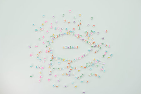 Colorful letters and symbols are scattered on a light background. The letters form the word symbols in the center. This scene shows a fun and creative arrangement of letters.の写真素材