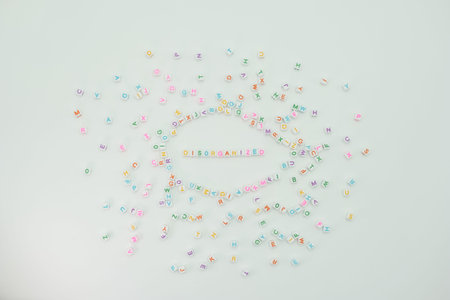 Colorful letters are scattered across a plain surface with a central focus on the word disorganized....
