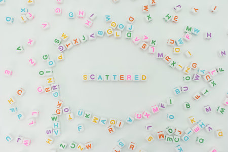 Small colorful plastic letters are placed on a flat surface with some letters scattered around. The...