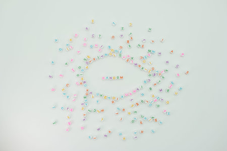 Small plastic letters of various colors are scattered across a flat surface. The letters form a...