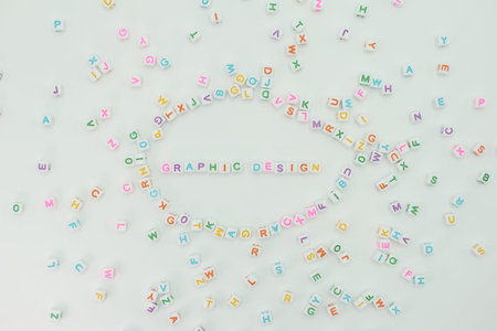 Colorful plastic letters are arranged to spell graphic design with random letters scattered around...