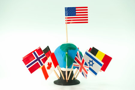 Students create a globe out of clay and place flags from various countries around it. The project takes place in a classroom where they learn about different cultures.の写真素材