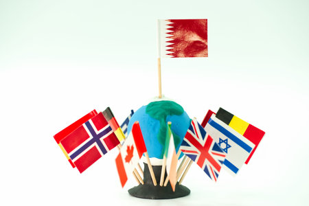 A creative model of the earth is surrounded by flags of various countries. The flag of Bahrain is on top, and the scene is set against a plain white background.の写真素材