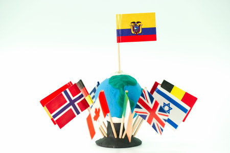 A globe made from clay sits on a table surrounded by flags from various countries. This setup is for...