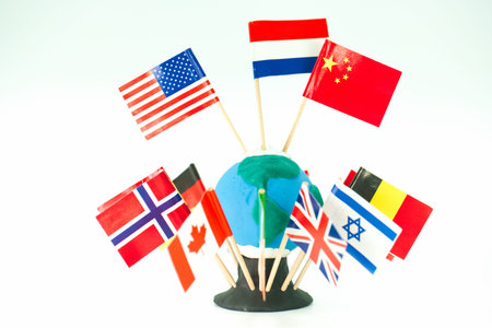 A blue and green globe sits on a black base with flags from various countries attached with...