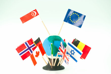 Small globe made of clay with flags from various countries stick out. This scene shows a classroom project where students learn about different cultures and nations.の写真素材