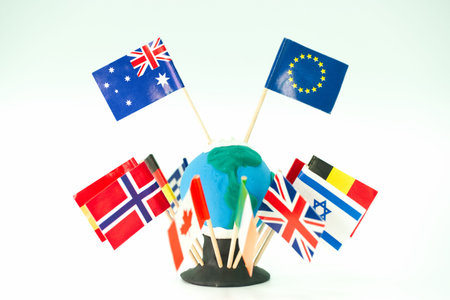 A globe is made of clay and is surrounded by small flags representing various countries. This scene takes place in a classroom where students learn about geography and cultures.の写真素材