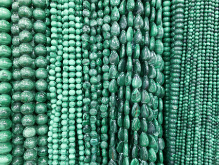 Different types of green beads are shown in a shop. The beads come in various shapes and sizes. Customers can look at these beads for crafting and design projects.の写真素材