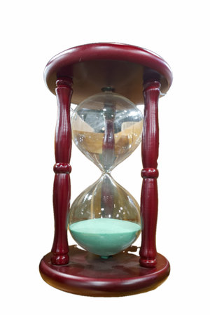 A wooden hourglass stands upright with sand flowing from the top chamber to the bottom chamber....