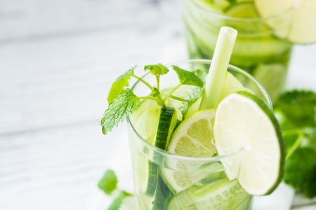 Close up of refreshing drink with cucumber, lime, mint. Detox concept. White rustic tableの写真素材