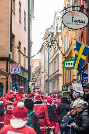 STOCKHOLM, SWEDEN â DECEMBER 11, 2016: People dressed up as santas run through the Old Town of Stockholm, participating in charity event Stockholm Santa Run in Swedenのeditorial素材