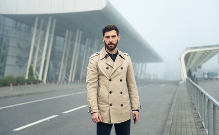 Young businessman in trench coat